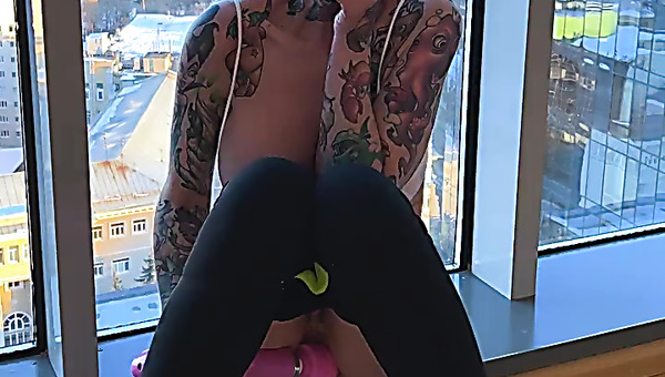 Busty bald alt bitch masturbates at the window with a pink vibrator!